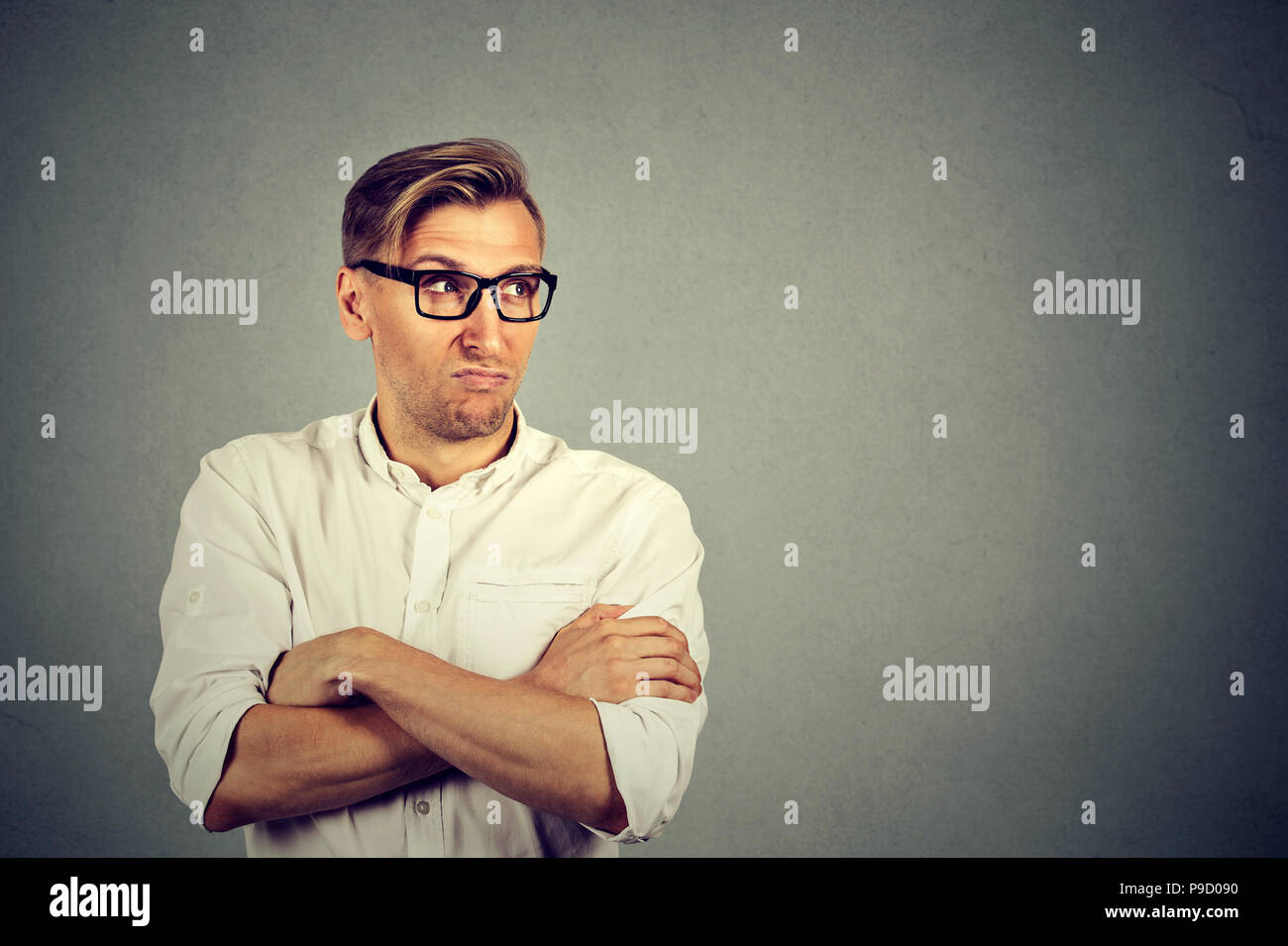 Erwachsener Mann im weißen Hemd und Brille, das Hände gekreuzt und Suchen grumpy Eifersucht und Neid Stockfoto