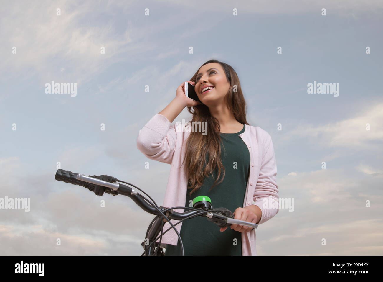 Junge Frau lehnte sich auf dem Fahrrad und am Telefon sprechen Stockfoto