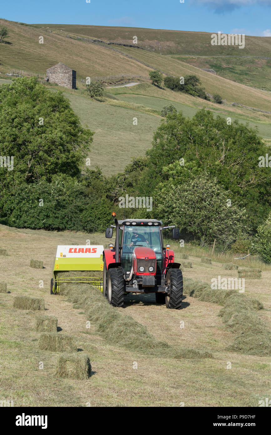 Landwirt in Swaledale, North Yorkshire, Heuballen, mit einem Massey Ferguson 5470 und ein CLAAS Rundballenpresse. Stockfoto