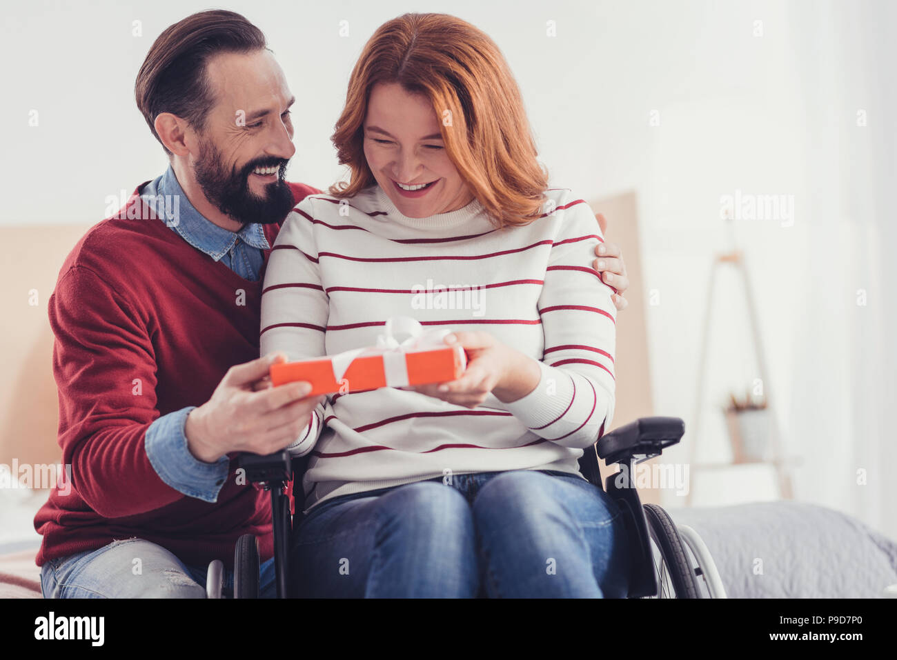 Emotionale Mann lächelnd, während sie ein Geschenk an seine Schwester mit einer Behinderung Stockfoto