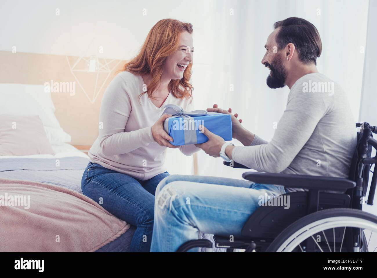 Emotionale Frau lachend, während Sie ein Geschenk zu ihrem behinderten Bruder Stockfoto