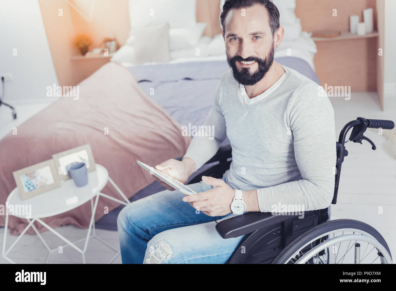 Begeisterte junge Mann sitzt im Rollstuhl und der Suche nach einem Job Stockfoto