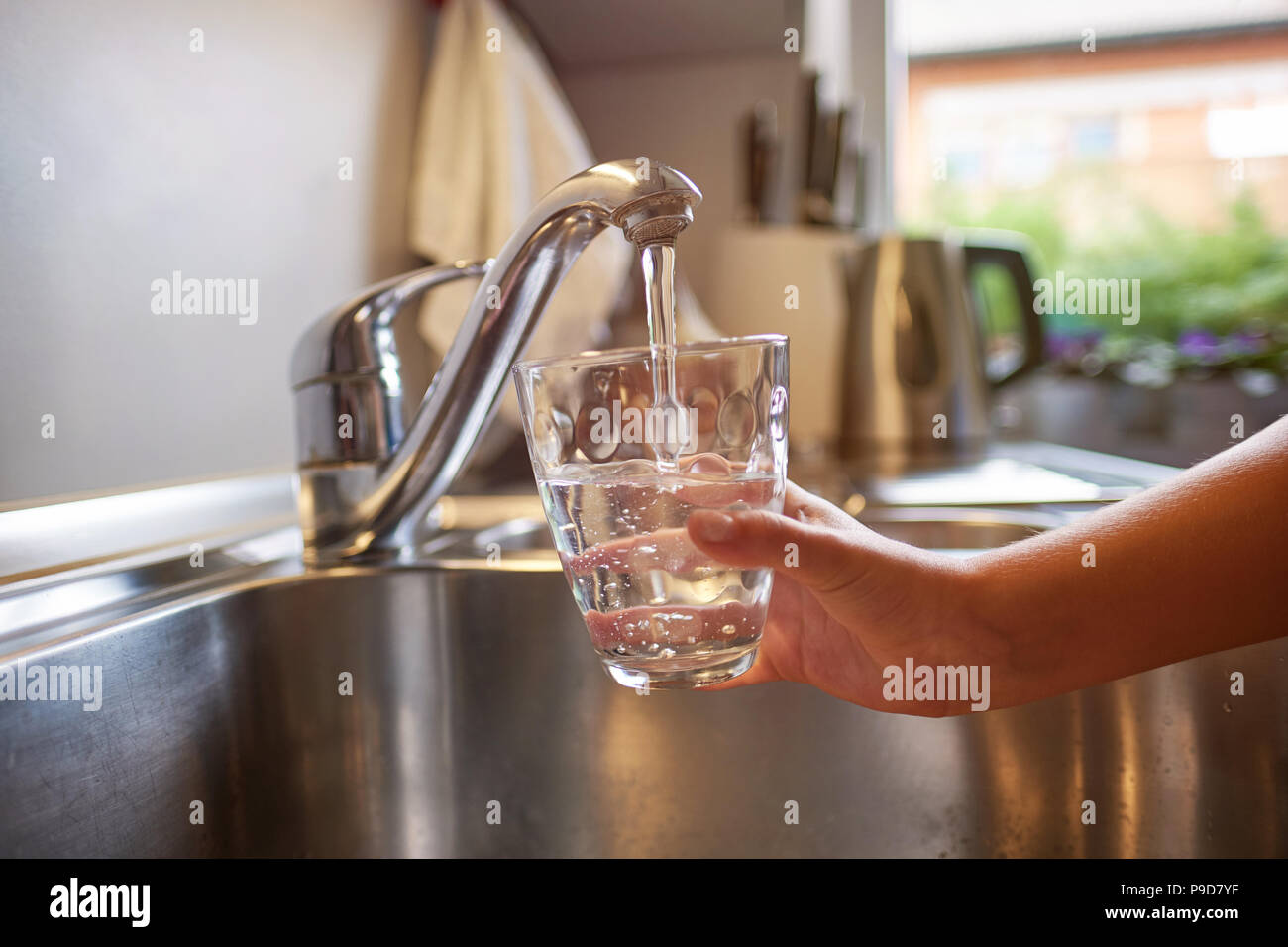 In der Nähe von Frau und Kindern Hände, gießen ein Glas frisches Wasser aus der Küche tippen Stockfoto