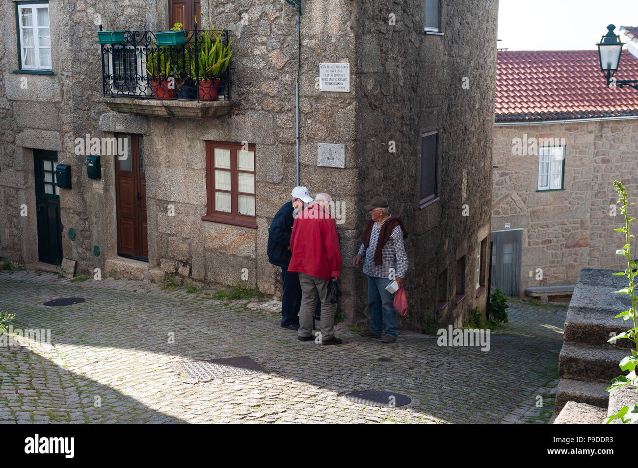 12.06.2018, Monsanto, Portugal, Europa - Drei ältere Männer sind gesehen in einem Chat vor einem Wohnhaus im Dorf von Monsanto. Stockfoto