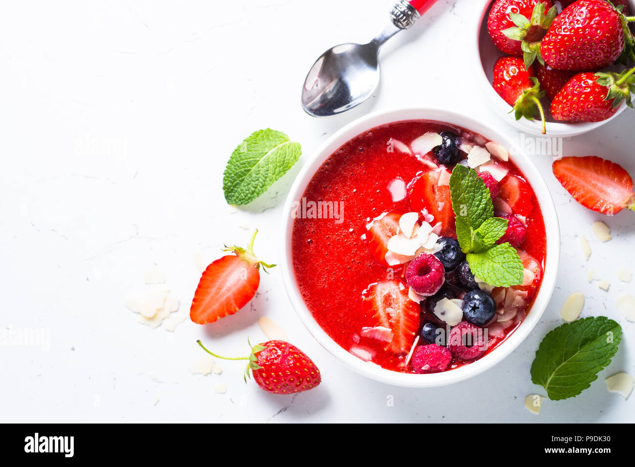 Smoothie Schale aus Erdbeeren mit frischen Beeren und Mandel. Ansicht von oben auf weißem Hintergrund. Stockfoto