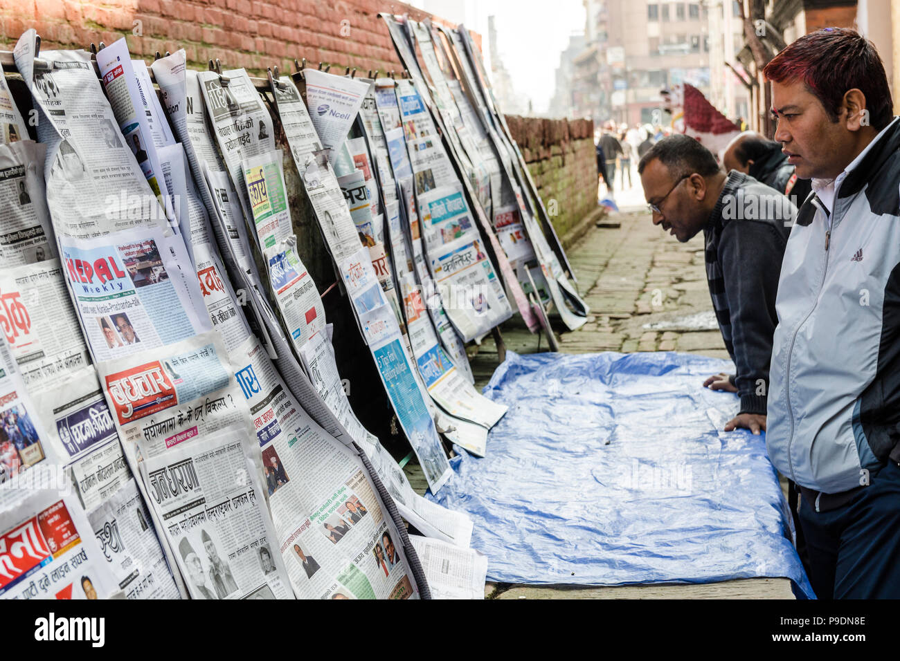 Lokale Zeitung lesen" Schlagzeilen in Basantapur Durbar Square, Kathmandu, Nepal Stockfoto