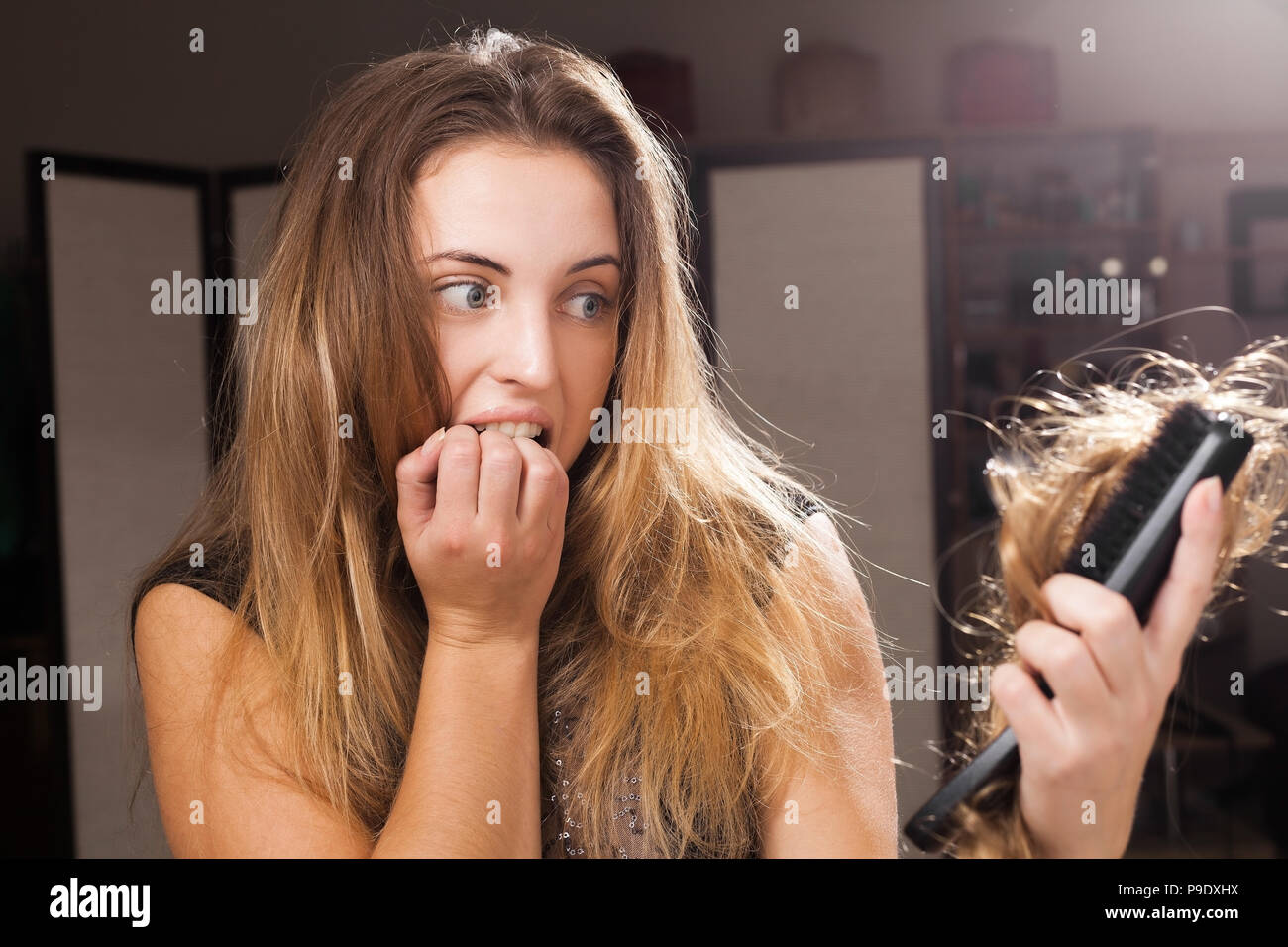 Erschrocken hübsches Mädchen entdecken Haarausfall auf eine Haarbürste Stockfoto