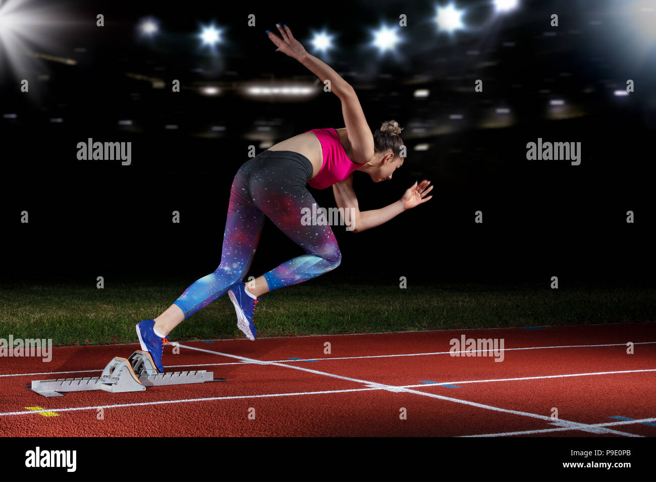 Frau Sprinter verlassen Start auf der Leichtathletikbahn. explodierende Start am Stadion mit Reflektoren Stockfoto