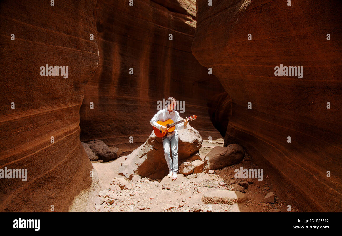 Gran Canaria, glatte Wände der Schlucht Barranco de las Vacas zwischen Temisas Agüimes, Teenager und Gitarre spielen Stockfoto