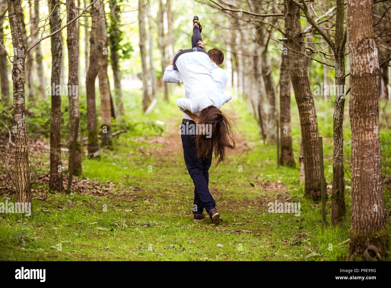 Intelligent junge Mann Junge führen der Dame über die Schulter durch Herbst Wald angezogen Stockfoto