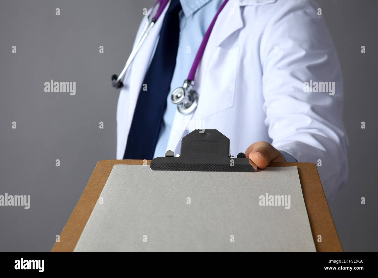 Der Arzt im weißen Kittel mit einem medizinischen Stethoskop Holding einen Ordner Stockfoto