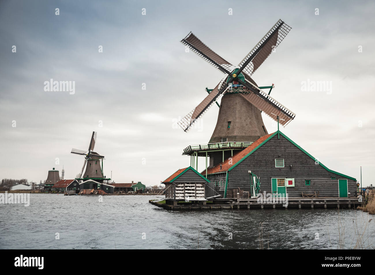 Windmühlen auf Fluss Zaan Küste, Zaanse Schans Stadt, beliebten touristischen Attraktionen der Niederlande. Vorort von Amsterdam Stockfoto
