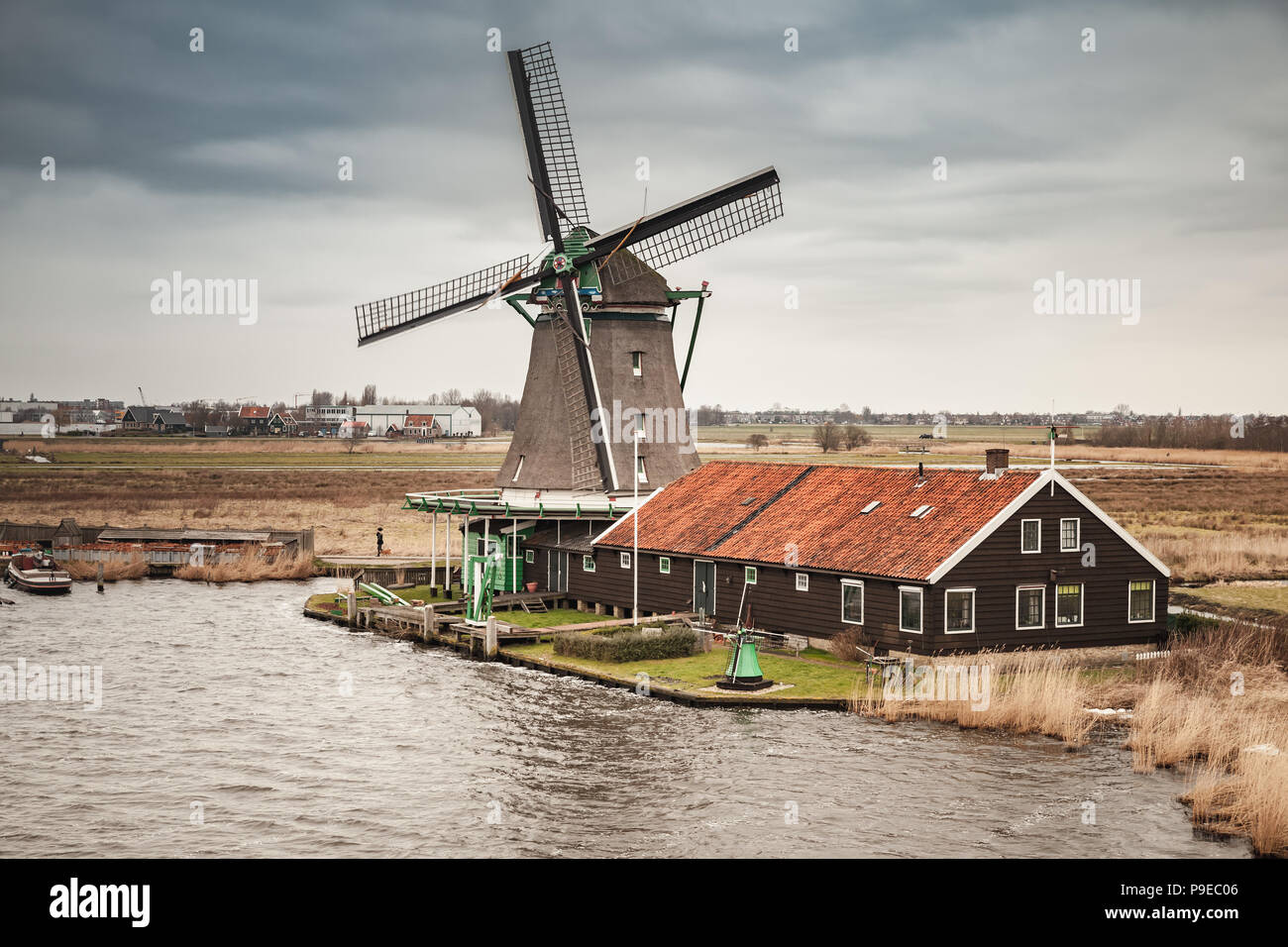 Mühle am Fluss Zaan Küste, Zaanse Schans Stadt, beliebten touristischen Attraktionen der Niederlande. Vorort von Amsterdam Stockfoto