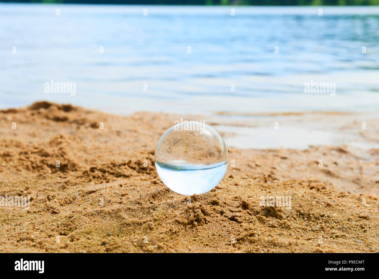 Glas Kugel am Sandstrand Stockfoto