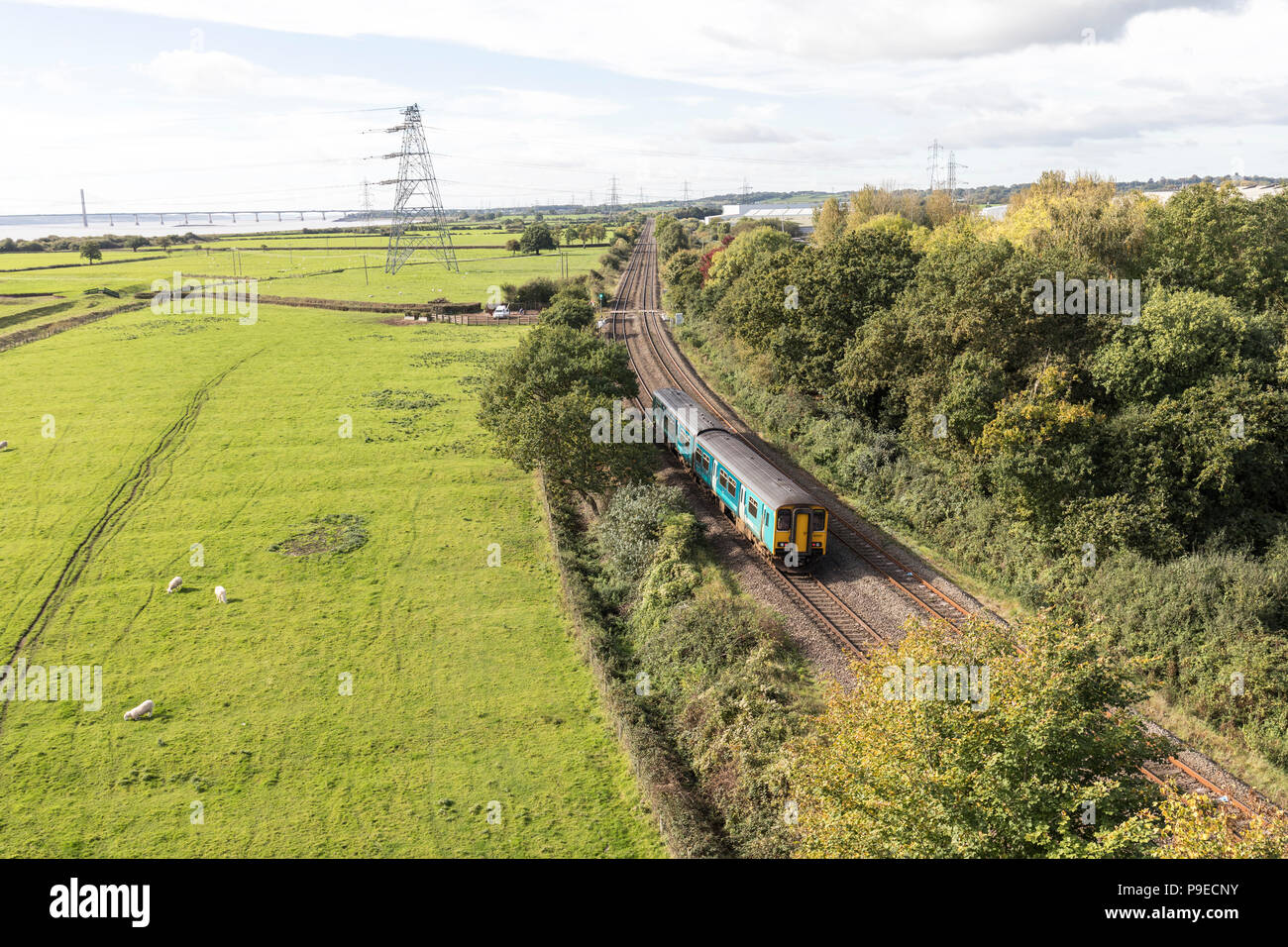 Eisenbahn neben dem Fluss Severn mit Straßenbrücke im Abstand in Newport, Wales, Großbritannien Stockfoto