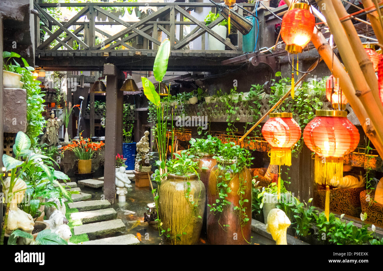 Ein Holzsteg über den Garten in der Straßenbahn Cafe in Ho Chi Minh City, Vietnam. Stockfoto