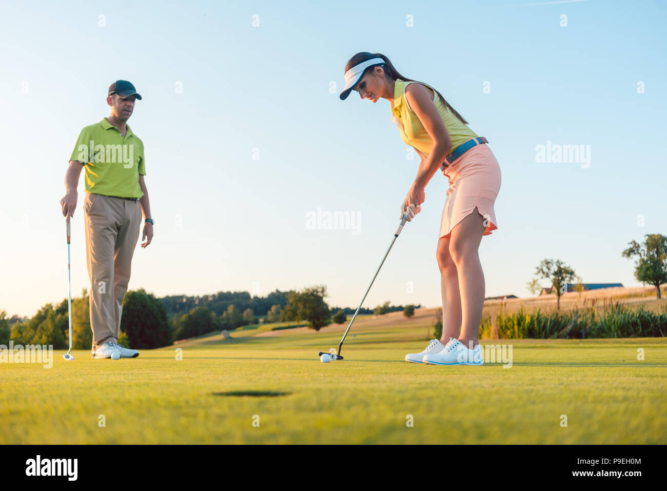 Die volle Länge einer Frau spielen professionelle Golf mit ihrem männlichen Partner Stockfoto