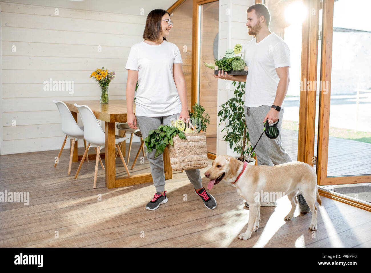 Paar nach Hause kommen mit Hund und Essen Stockfoto