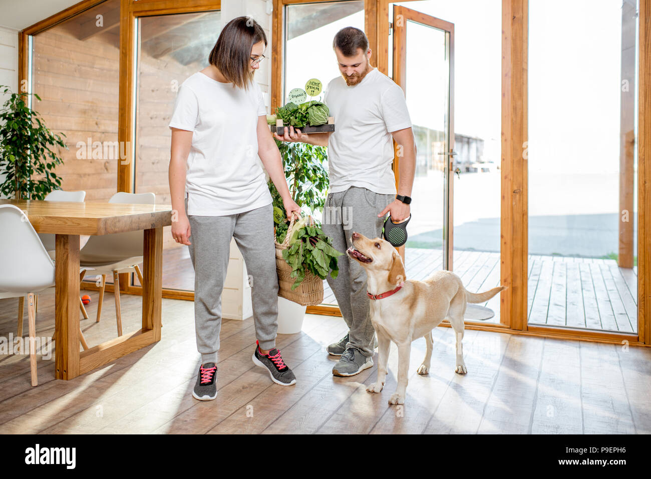 Paar nach Hause kommen mit Hund und Essen Stockfoto