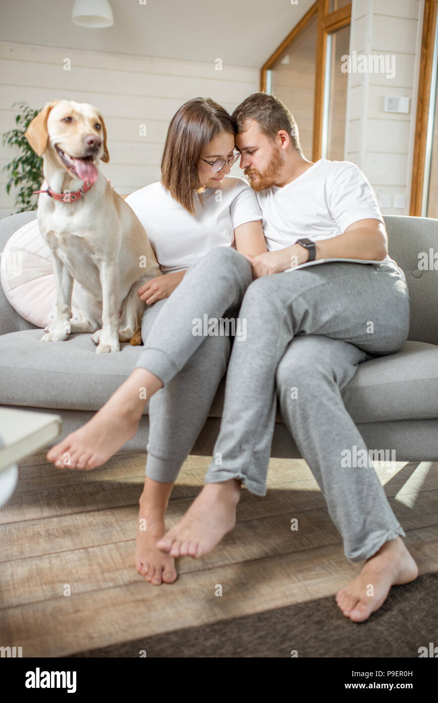 Paar mit Hund auf der Couch zu Hause Stockfoto