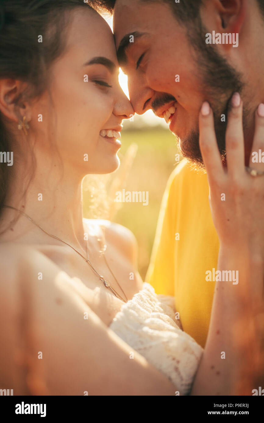 Portrait von lächelnden verliebte Paare an der Wiese. Mit Hintergrundbeleuchtung. Stockfoto