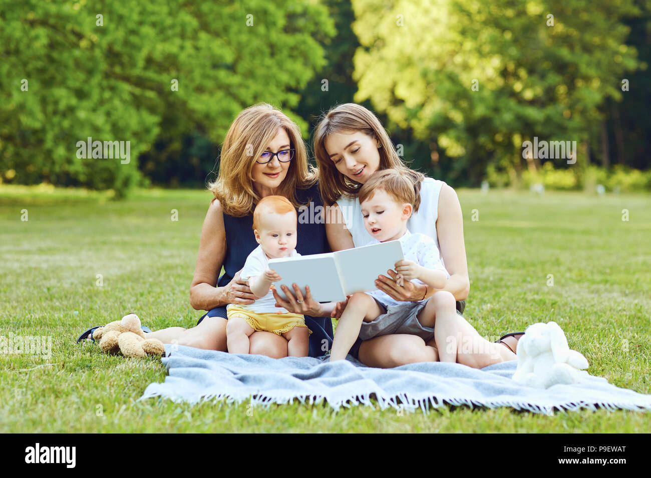 Mutter und Großmutter lesen Sie das Buch mit dem Kind. Stockfoto