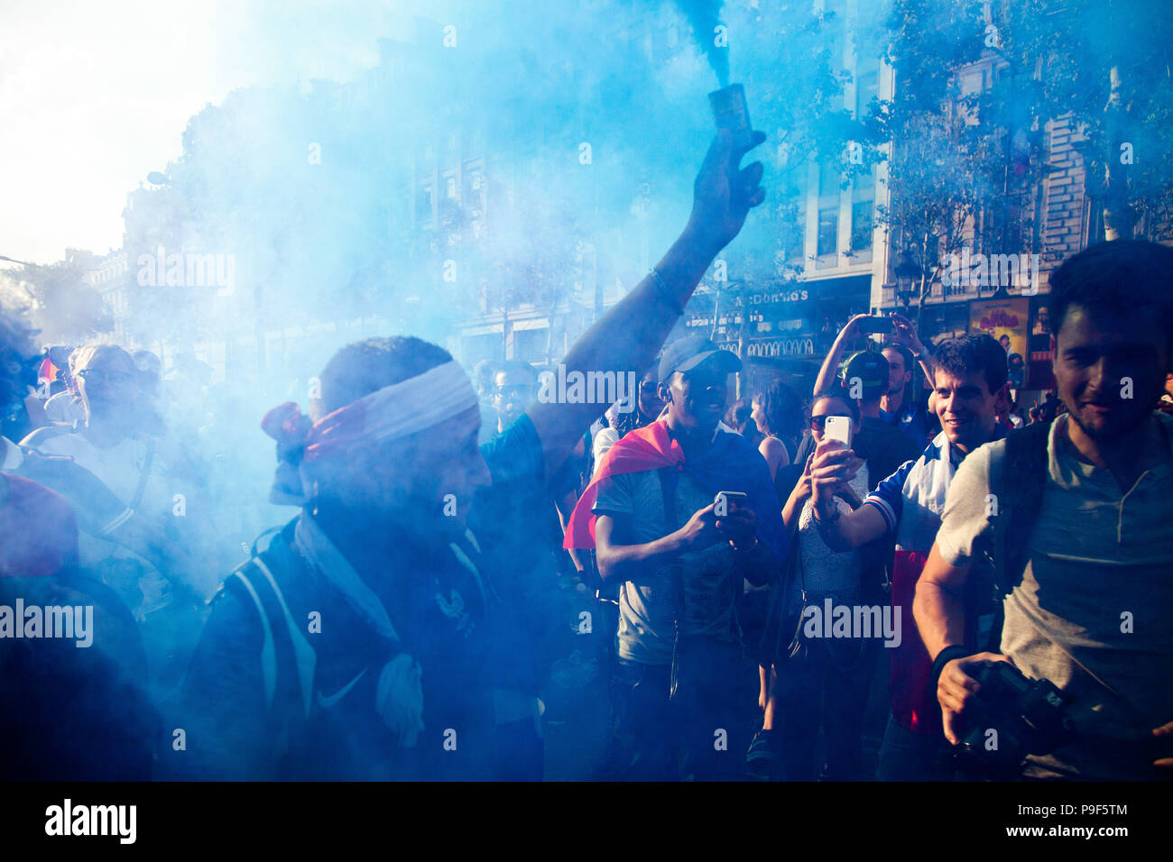 Paris, Frankreich. 16. Juli 2018. Ein Mann gesehen, ein Aufflackern, wie Tausende von Anhängern Raffungen an Champs Elysées Weltmeister französische Fußball-Nationalmannschaft zu erhalten. Am Samstag, den 15. August, Frankreich beated Kroatien durch die Kerbe von 4-2, immer der Champion der World Cup zum zweiten Mal in der Geschichte. Credit: Joao Bolan/SOPA Images/ZUMA Draht/Alamy leben Nachrichten Stockfoto