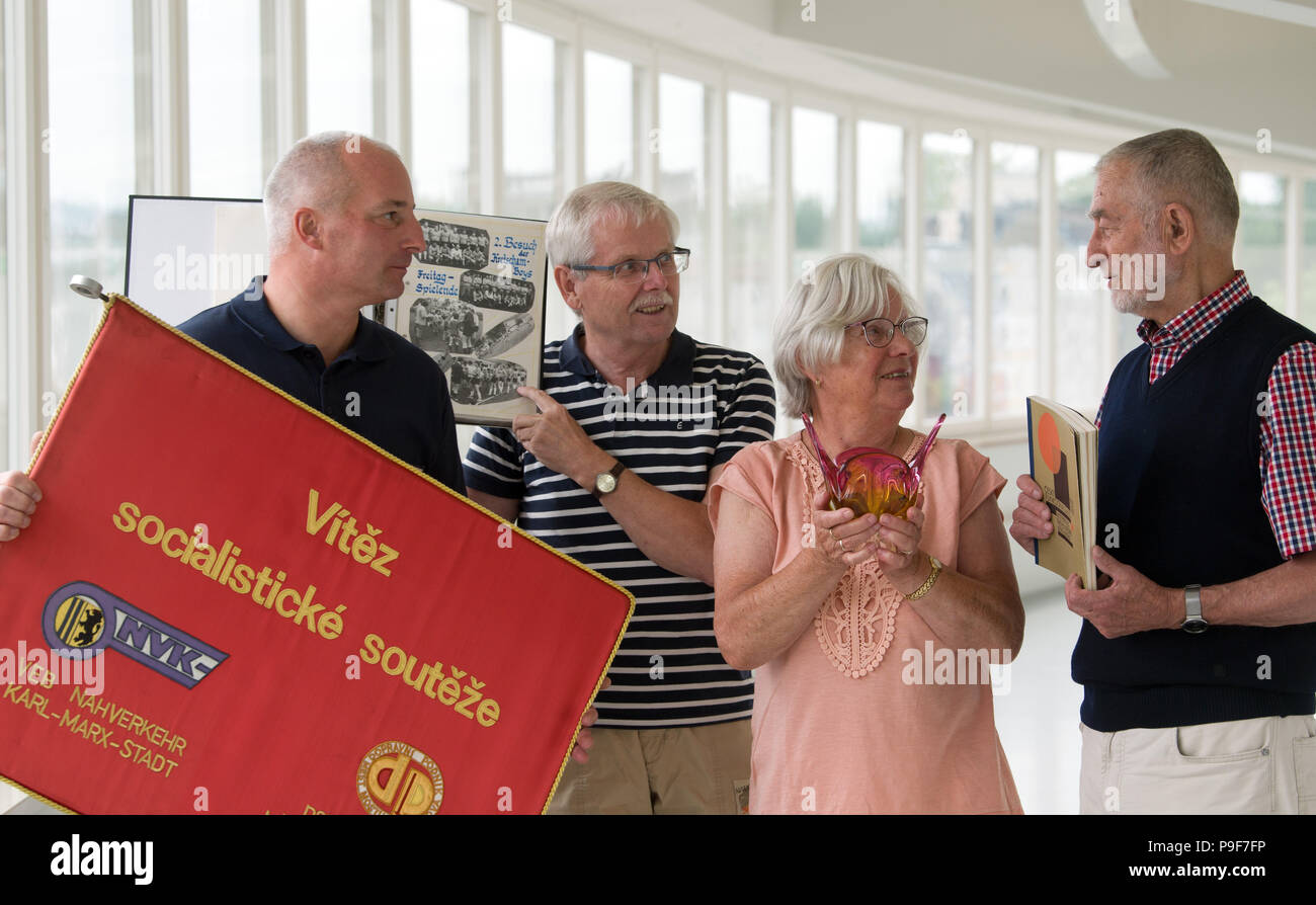 18. Juli 2018, Chemnitz, Deutschland: Thomas Laube (L-R) von der 'Freunde der Straßenbahn Chemnitz "die Reisen Banner der sozialistischen Wettbewerb der Verkehrsunternehmen Karl-Marx-Stadt und Most-Litvinov, Roland Seifert hält mit einem eigenen Album auf grenzüberschreitende amateur Fussball, Siglinde Scheunert mit einem künstlerischen Schale aus Böhmischen Glas und Karl-Clauss Dietel mit einem Programm der Tschechoslowakischen Kommunistischen Partei von 1968 und eine show Katalog auf den tschechischen Funktionalismus von 1978 an der einleitenden Präsentation im Museum für Archäologie in Chemnitz statt. Die spezielle Ausstellung axony Bo Stockfoto