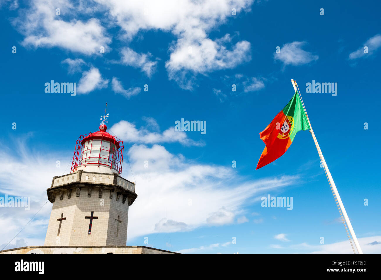 Leuchtturm und blauer Himmel auf Sao Miguel, Azoren mit portugiesischen Flagge Stockfoto