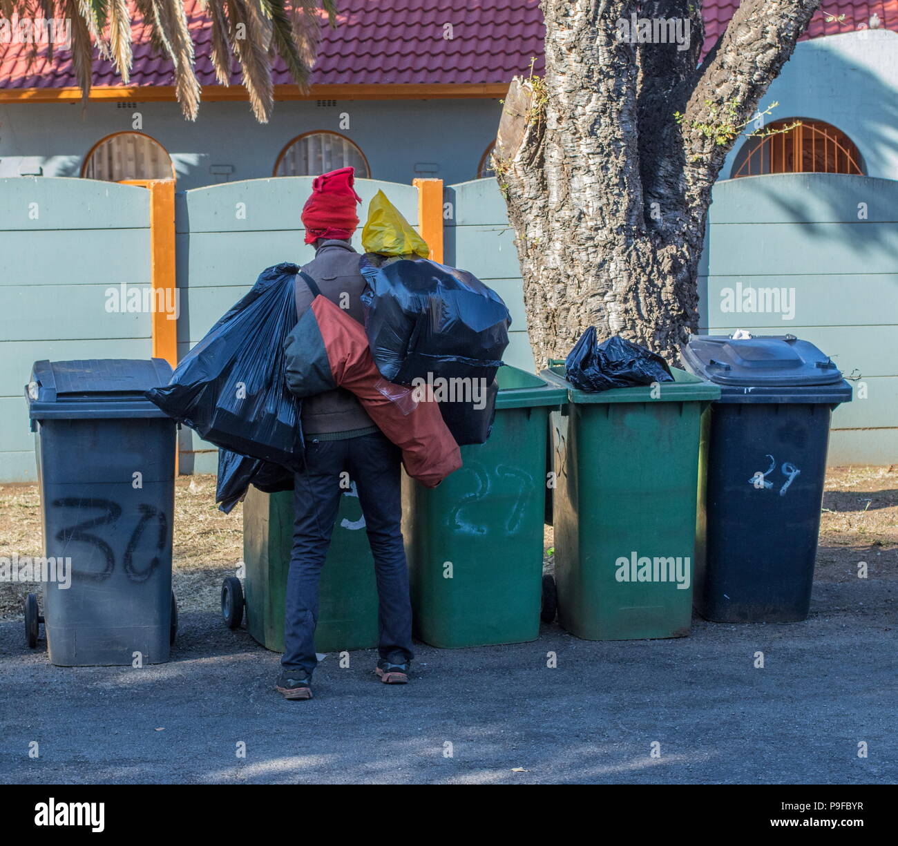 Johannesburg, Südafrika - ein nicht identifizierter arbeitslosen Mann sucht durch Wohn- abfallbehälter Bild mit Kopie Raum im Querformat. Stockfoto