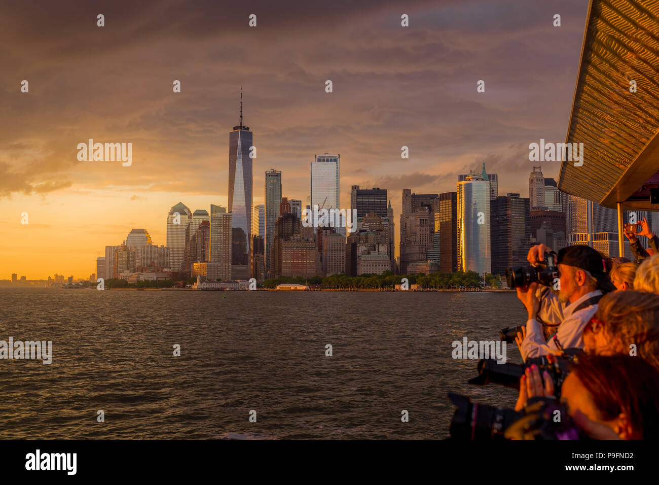New York, NY, USA - Juni 4, 2018. Fotografen, die spektakulären Sonnenuntergang Fotos vom Kreuzfahrtschiff mit Lower Manhattan in backgournd. Stockfoto