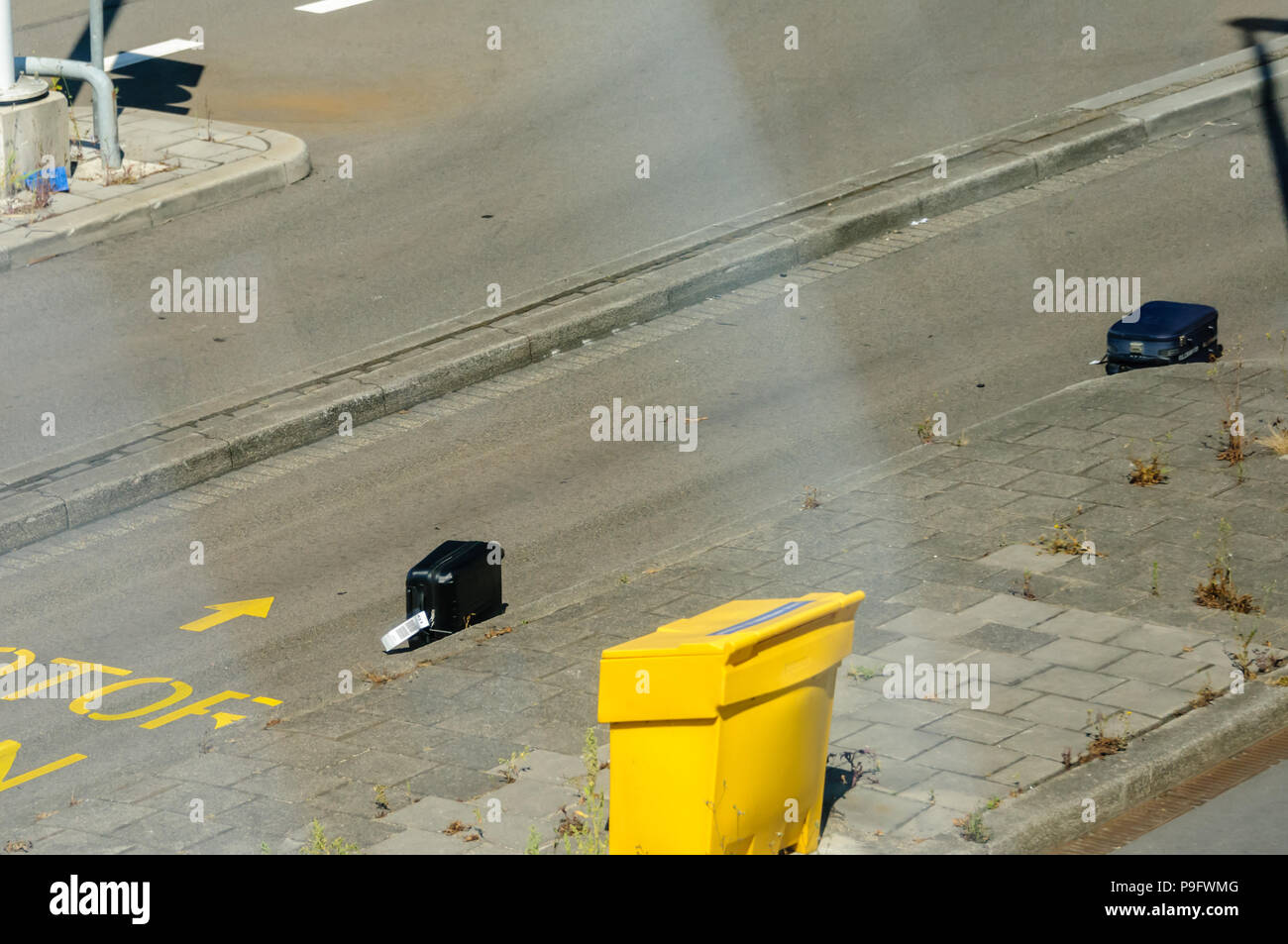 Passagiere Gepäck Koffer liegen auf einem Flughafen Straße, nachdem sie weg von einer Gepäck Lkw, Gepäck verloren. Stockfoto