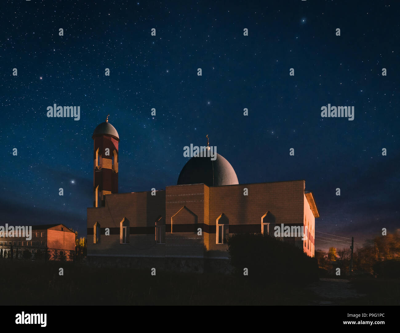 Beleuchtete Moschee bei Nacht mit fantastischen Himmel und Sterne Stockfoto