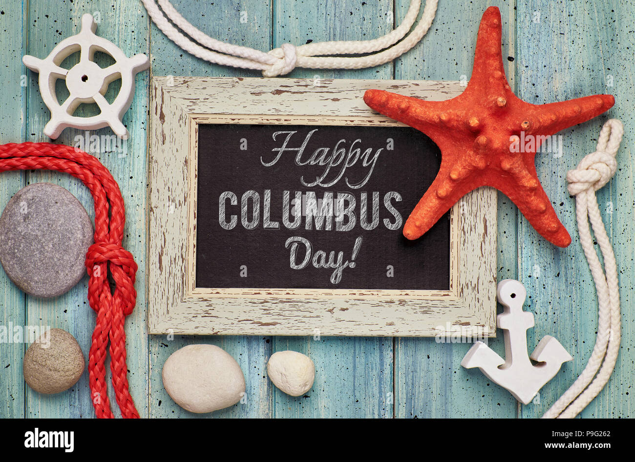 Leere Tafel mit Muscheln, Seil, Anker und Stern Fisch auf hellem Holz, Text "Happy Columbus Day" Stockfoto