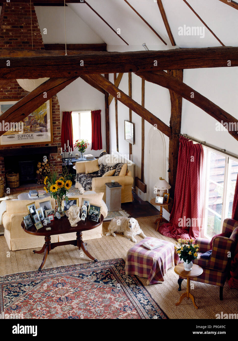 Birds Eye View einer Scheune Wohnzimmer mit cremefarbenen Sofas und einem antiken Tisch mit einer Gruppe von Fotos Stockfoto