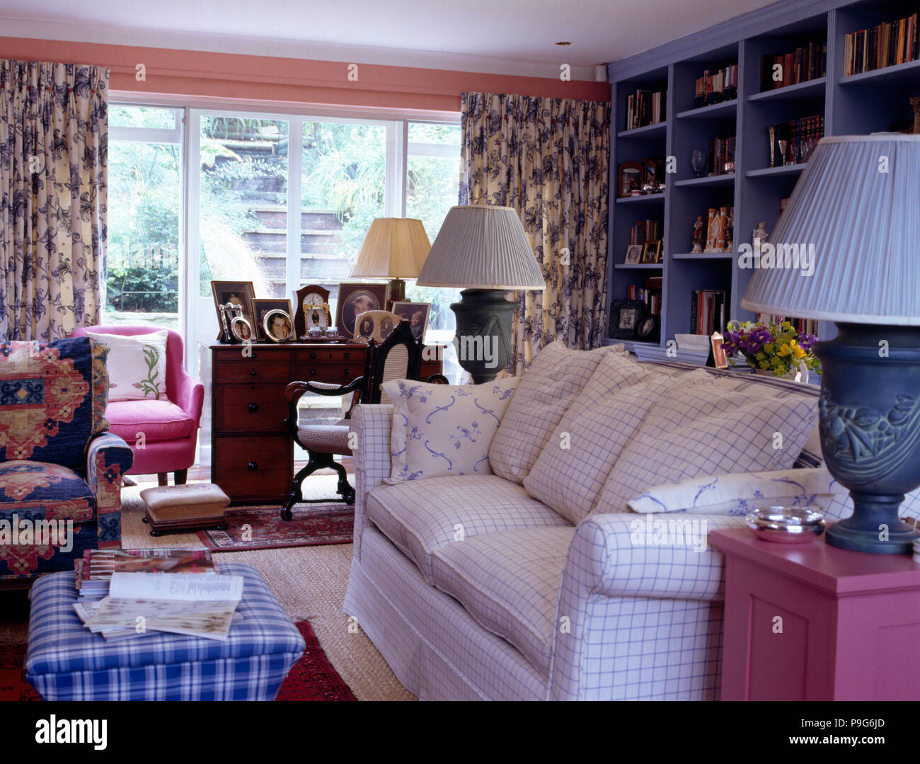 Blue überprüft osmanischen Hocker und geprüft, weiß Sofa im Wohnzimmer mit blauen Würfel Vitrinen Stockfoto