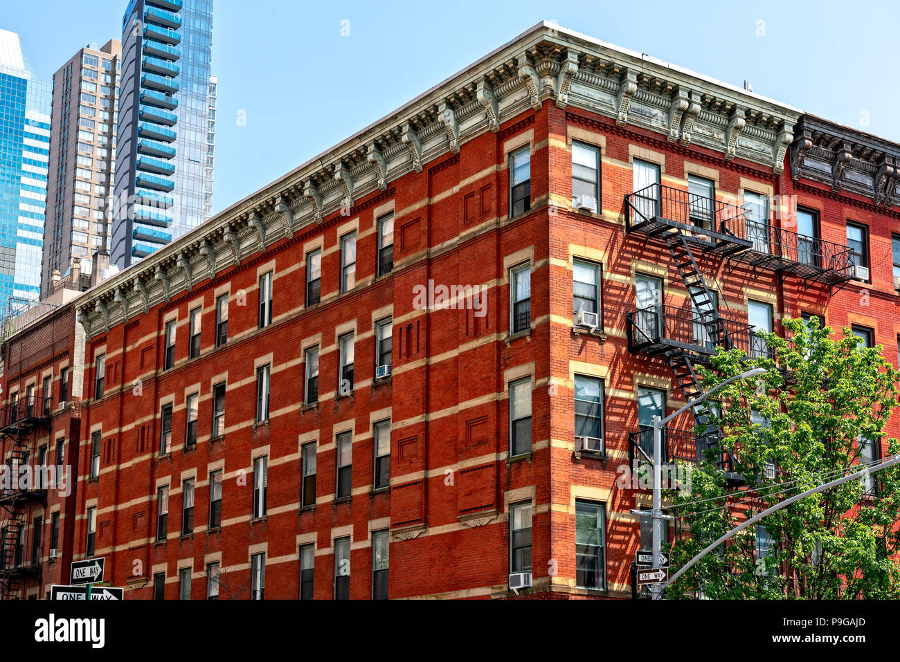 Manhattan, New York City. Betrachten oben Tenement Gebäude auf 9. Avenue in der Clinton/Hell's Kitchen Nachbarschaft, kontrastierende Neue Wolkenkratzer in Stockfoto