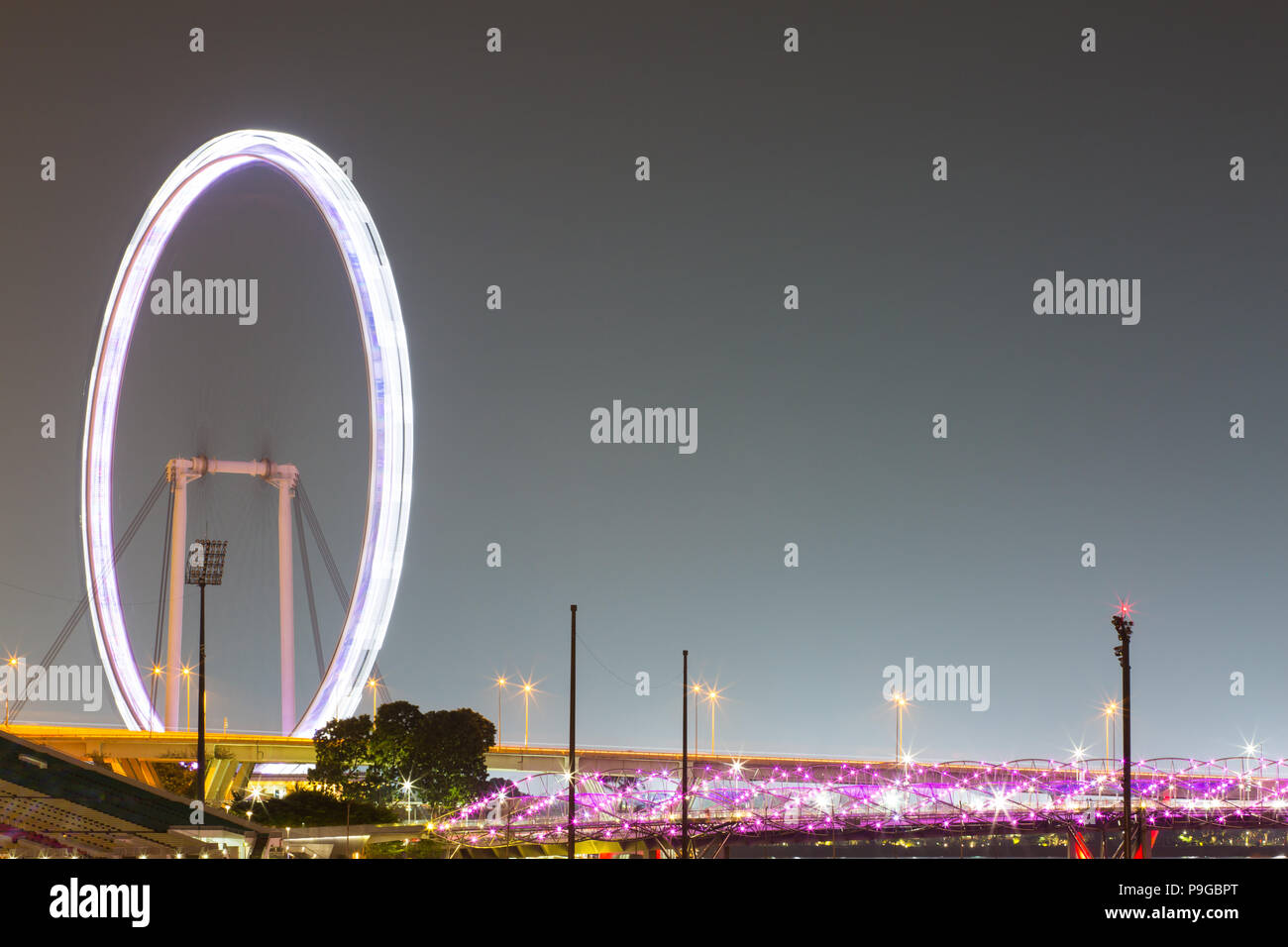 Light Trail von Singapur Flyer und die Helix-Brücke in lila beleuchtet. Stockfoto