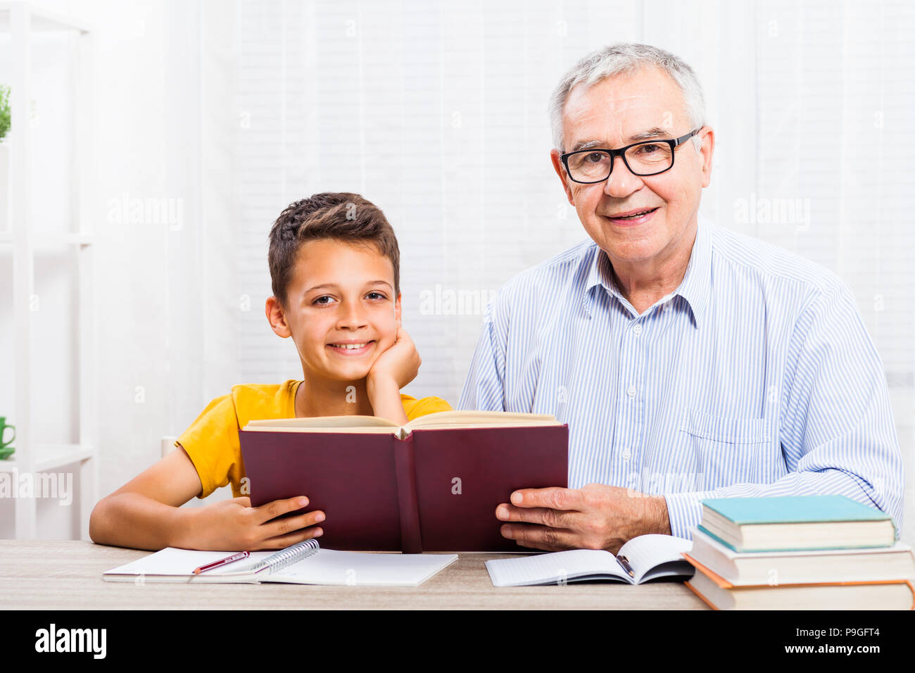 Großvater und Enkel lesen Buch zu Hause. Stockfoto