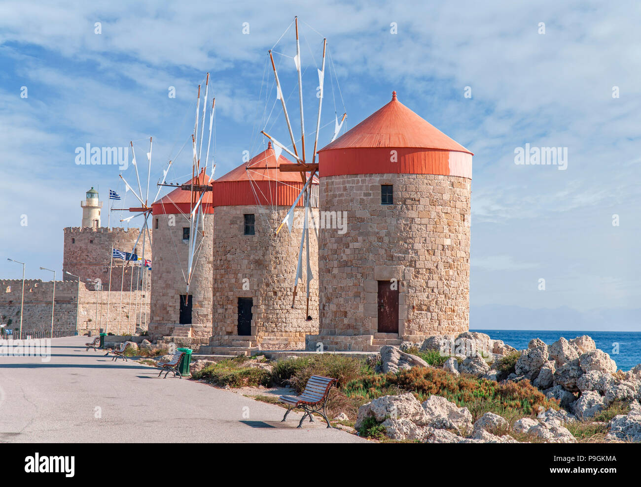 Drei alte Windmühle an der Küste mit blauen bewölkt skay und Leuchtturm im Hintergrund Stockfoto