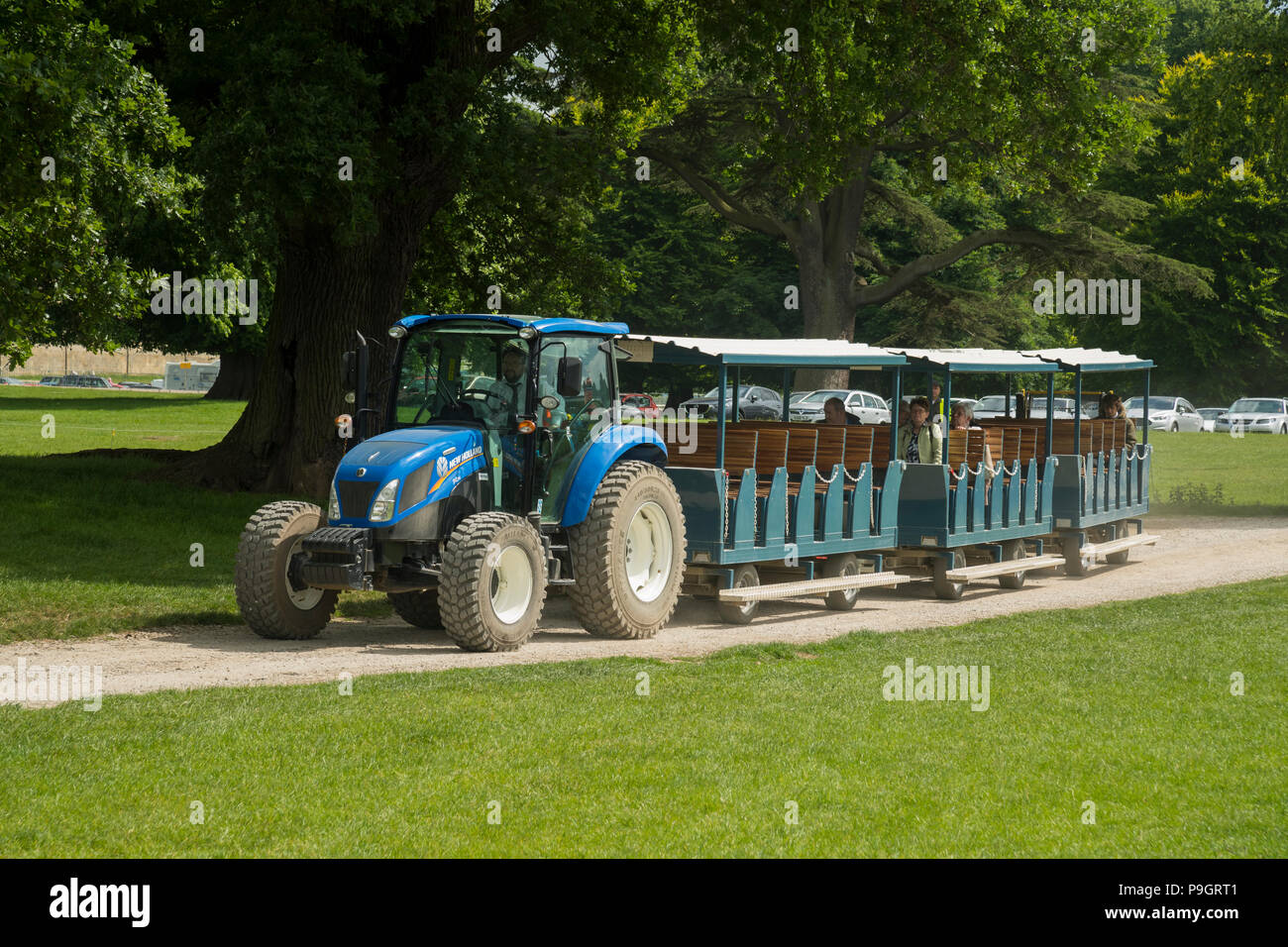 Besucher kommen zu Showground, transportiert vom Parkplatz in Kutschen durch die blauen Traktor gezogen - RHS Chatsworth Flower Show, Derbyshire, England, UK. Stockfoto
