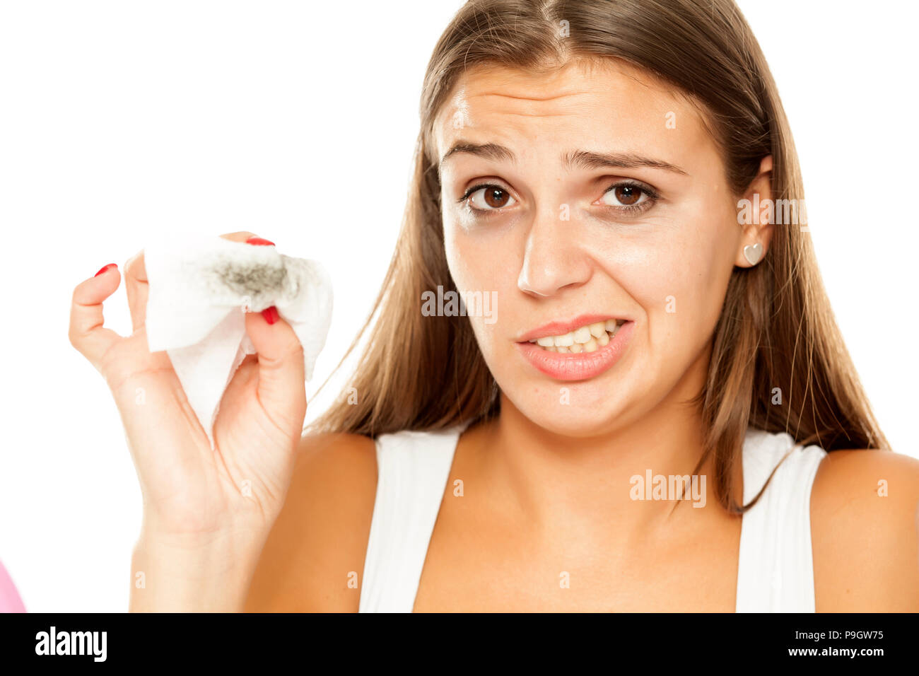 Junge schöne Frau entfernen Make-up auf dem Gesicht. Stockfoto