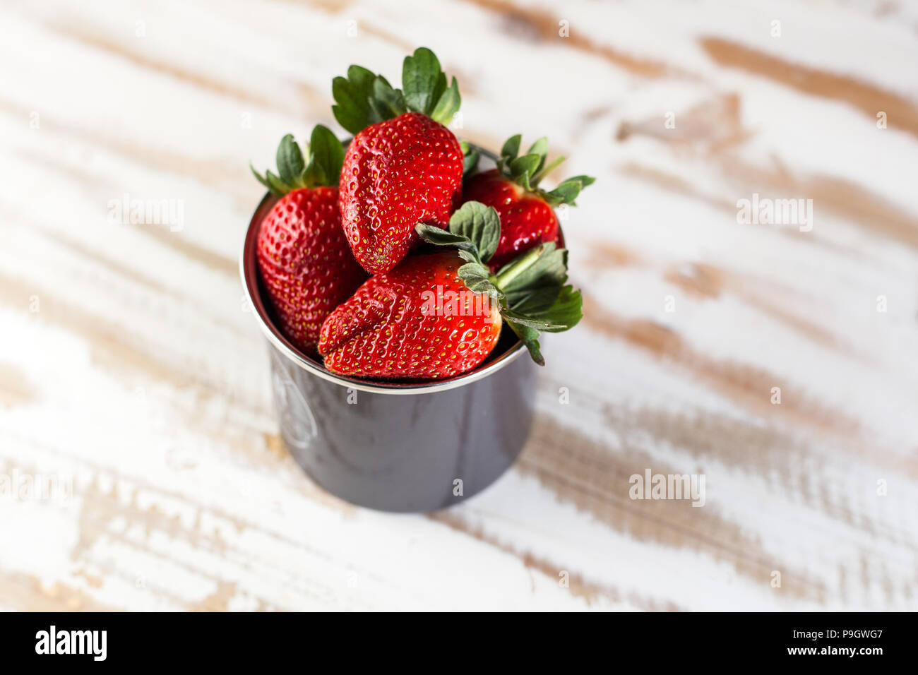 Rote Erdbeeren in einer Schale auf Weißen Holz Oberfläche. Gesundes Essen. Stockfoto