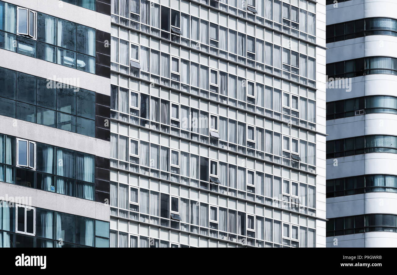 Moderner urbaner Architektur. Zusammenfassung Hintergrund Muster mit Mehrfamilienhaus. Betonwände mit blauen Fenstern Stockfoto