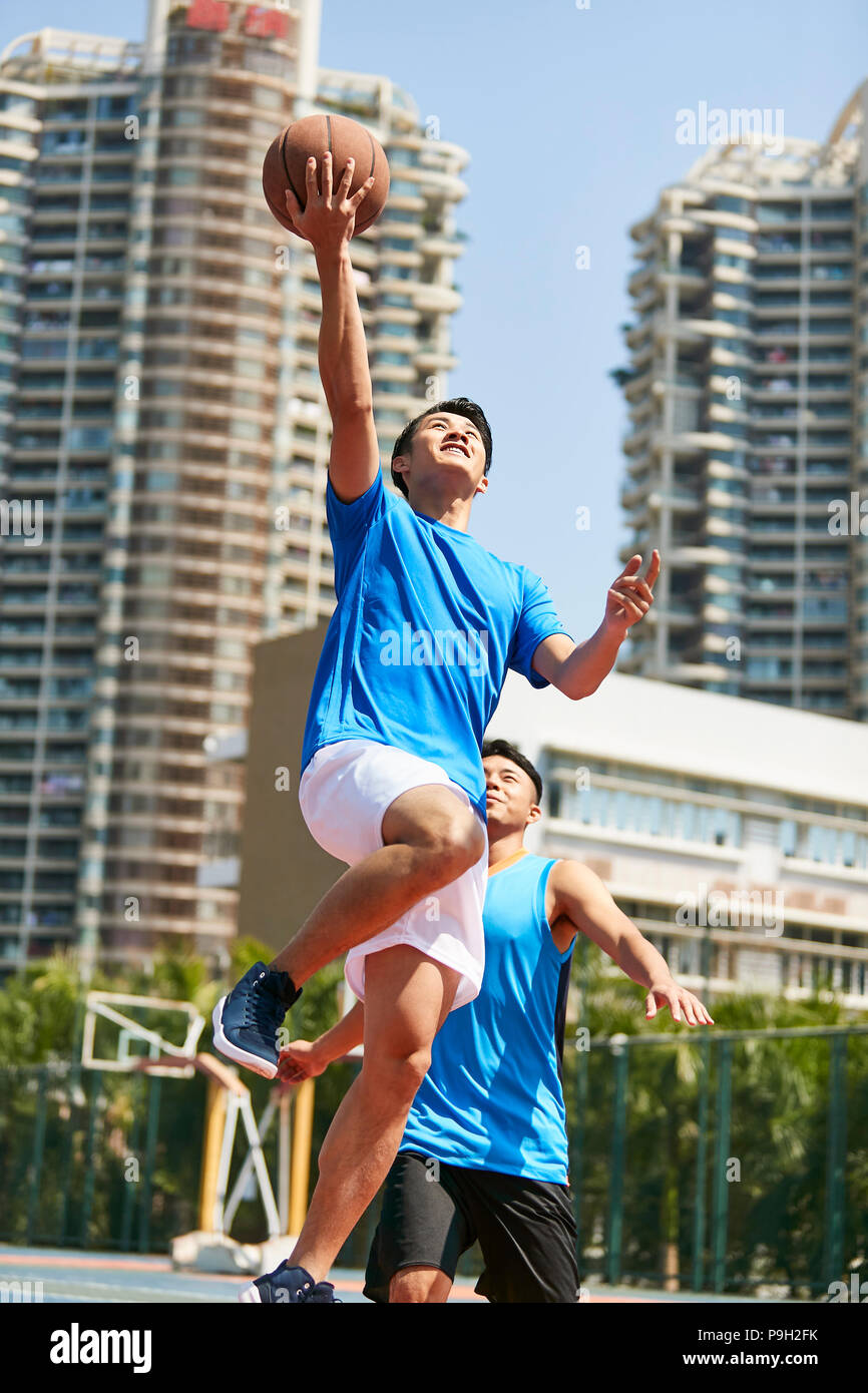 Jungen asiatischen Erwachsener Spieler Basketball spielen im Freien Gericht. Stockfoto