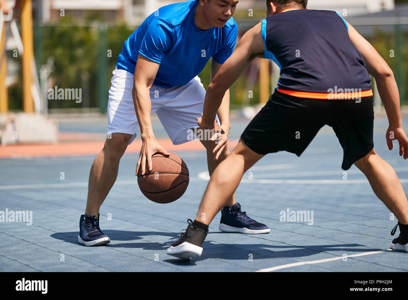 Jungen asiatischen Erwachsener Spieler Basketball spielen im Freien Gericht. Stockfoto