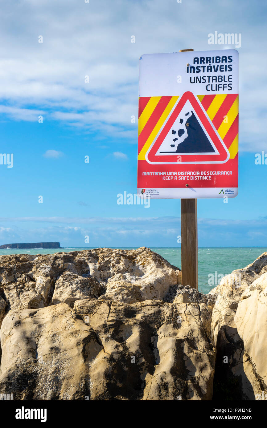 Warnschild Warnung von instabilen Klippen in Englisch und Portugiesisch Stockfoto