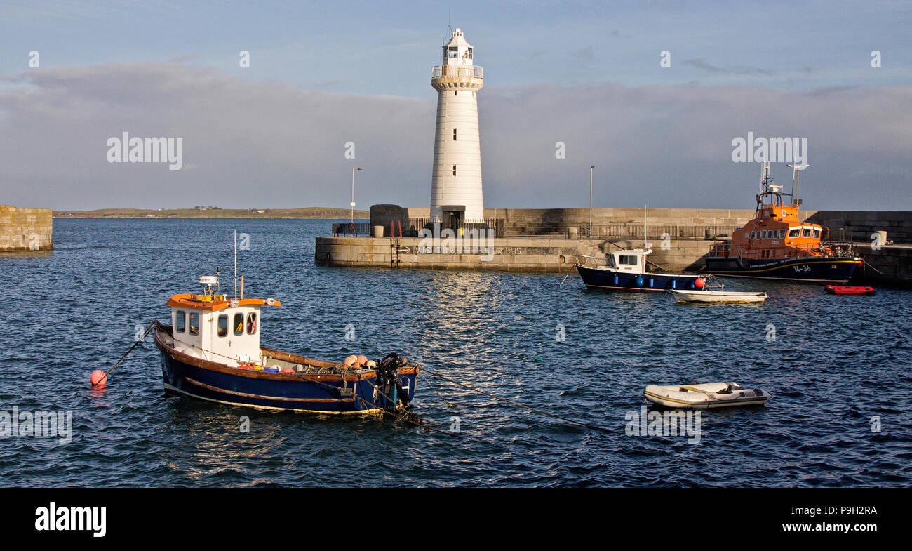 Kleine Boote, Leuchtturm und Rettungsboot an einem sonnigen Tag an Donaghadee Hafen, Nordirland. Stockfoto