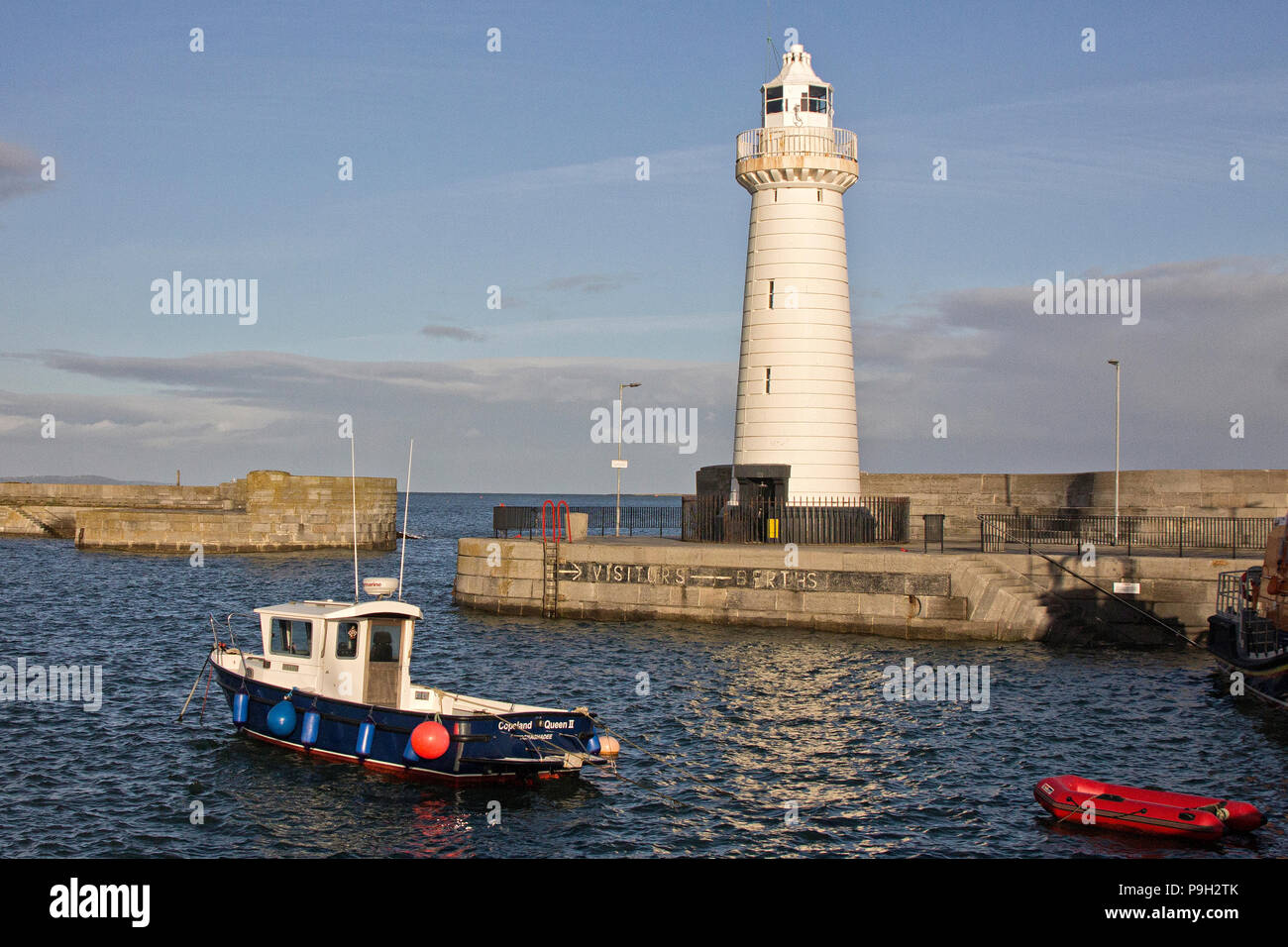 Kleine Boote und den Leuchtturm an einem sonnigen Tag an Donaghadee Hafen, Nordirland. Stockfoto