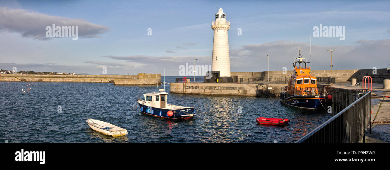 Panoramabild von kleinen Booten, den Leuchtturm und Rettungsboot an einem sonnigen Tag an Donaghadee Hafen, Nordirland. Stockfoto